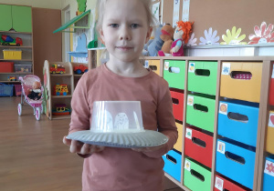 Nikola prezentuje statek kosmiczny z talerzyków papierowych.